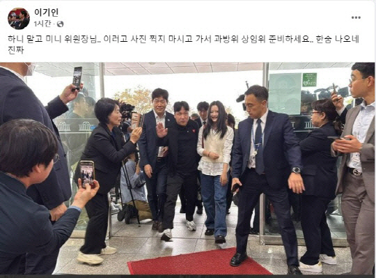 더불어민주당 소속 최민희(왼쪽에서 두번째)국회 과방위원장이 지난달 15일 국정감사에 참고인으로 출석한 뉴진스 하니의 인증샷을 찍고 있다. [이기인 개혁신당 최고위원 페이스북 캡처]
